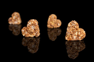 Group of four whole healthy brown cereal heart with cocoa isolated on black glass