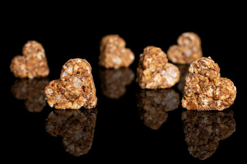 Group of six whole healthy brown cereal heart with cocoa isolated on black glass