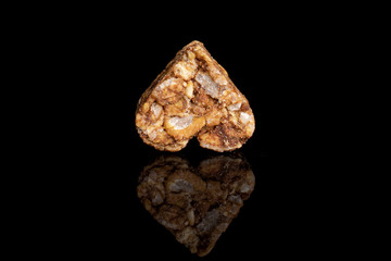One whole healthy brown cereal heart with cocoa isolated on black glass