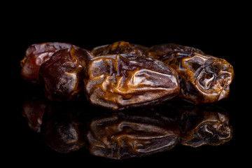Lot of whole dry brown date fruit isolated on black glass
