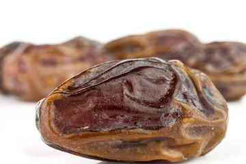 Lot of whole dry brown date fruit isolated on white background