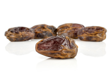 Group of five whole dry brown date fruit isolated on white background