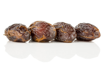 Group of four whole dry brown date fruit isolated on white background