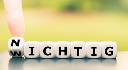 Wichtig oder Nichtig? Hand dreht einen Würfel und ändert das Wort 