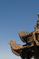 carved roof of a buddhist temple in asia against the sky