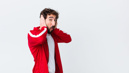 young bearded man back view looking unpleasantly shocked, scared or worried, mouth wide open and...