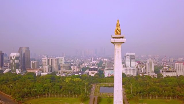 JAKARTA, Indonesia - 08 Juni 2019: Pemandangan udara dari Monumen Nasional Jakarta dengan kabut polusi udara. Ditembak dalam resolusi 4k dari drone