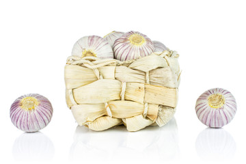 Lot of whole fresh purple single clove garlic in bast basket isolated on white background