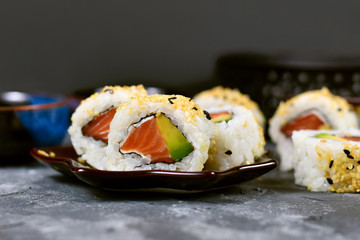 Sushi california roll filed raw salmon fish, avocado, cream cheese and topped with sesame 