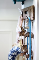 A vintage coat hook on a white wooden door , hanging with decorative ribbons and indian decorations, shallow depth of field interior image 