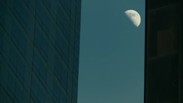 Romantic shot of moon between two New York skyscrapers. Timelapse