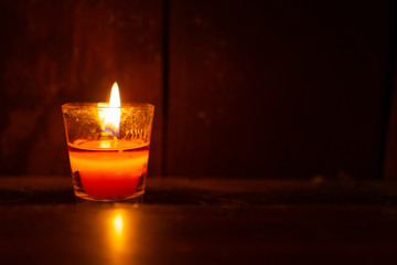 A bright candle light in the room with stained wall