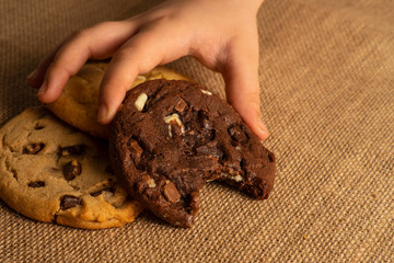 a children hand picking chocolate chip cookies