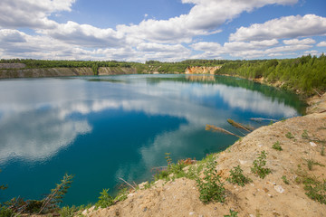 Fototapeta na wymiar Flooded quarry lake with blue water landscape