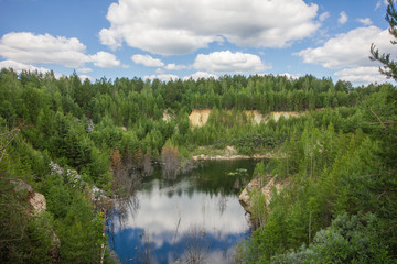 Fototapeta premium Flooded emerald quarry lake with blue water landscape