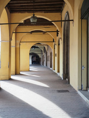 Ferrara, Italy. Ancient medieval loggia. Sunny day, shadow of the columns.