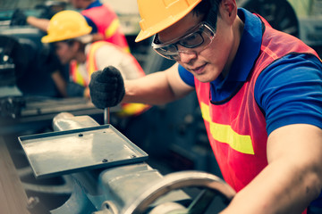 The industrial factory inspector wearing safety helmet and goggle watching on factory equipments to keep tracking safety work in industry factory area, Concept annual safety auditing and inspections.