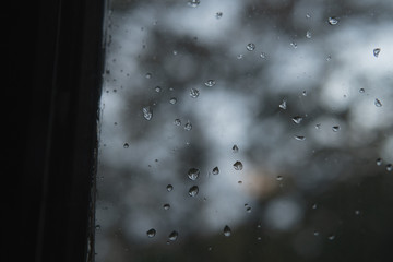 Rain drops on a window. Dark moody autumn concept