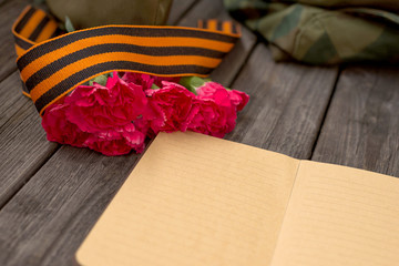 9 MAY. February 23. St. George's ribbon. Victory Day. Form, carnations, Notepad. Copyspace. Selective focus.