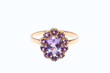 Beautiful golden ring with purple gemstone isolated on white background