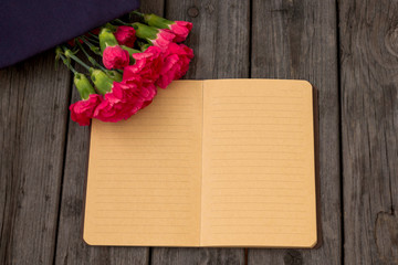 February 23. Fatherland defender day. Men's day of defenders of the Fatherland in Russia, Belarus, Tajikistan and Kyrgyzstan. Form, carnations, Notepad. Copyspace. Selective focus.