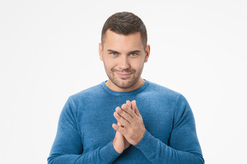 Young caucasian man making up evil plan in mind against white background