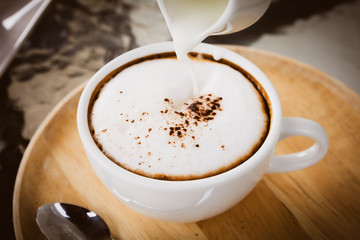 White cup of hot coffee latte drink in vintage style color.