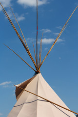 Indian wigwam in against the blue sky with clouds. © JoyNik