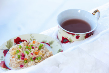 Oatmeal porridge with dried fruits with tea in the snow