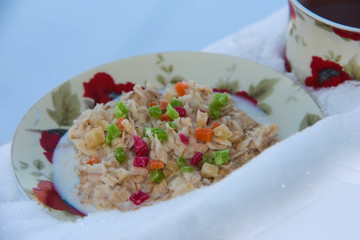 Oatmeal porridge with dried fruits with tea in the snow