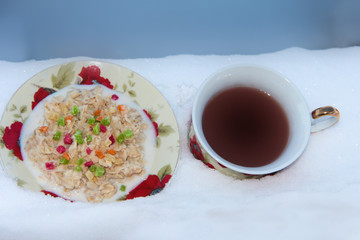 Oatmeal porridge with dried fruits with tea in the snow