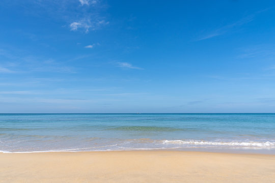 Ocean view and white sand beach with blue sky and a tiny wave background
