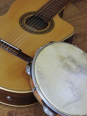 An acoustic guitar and a pandeiro (tambourine), a Brazilian percussion musical instrument, on a...