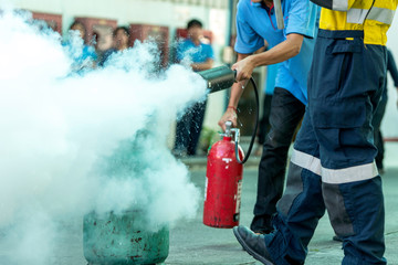 Man teaches how to use fire extinguisher to extinguish fire.