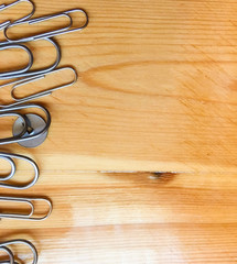 metal clips and pins on a wooden table. place for text