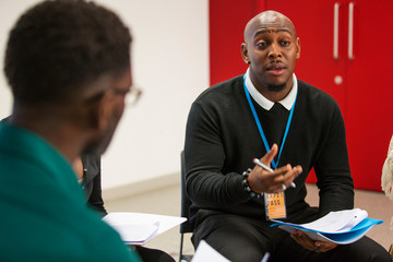 Businessman with paperwork talking leading meeting