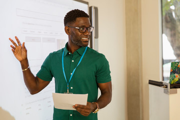 Male community college instructor at projection screen in classroom