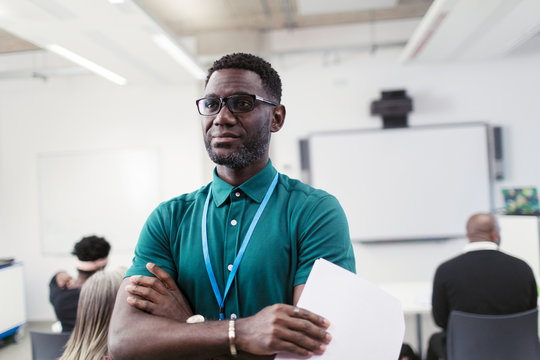 Portrait confident male instructor with arms crossed in classroom