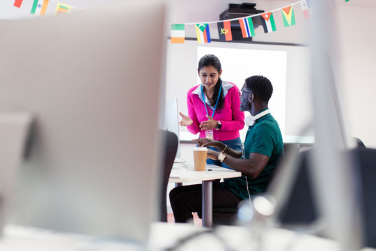 Community college instructor talking with student at computer