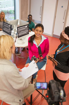 Community college journalism students at microphone in classroom