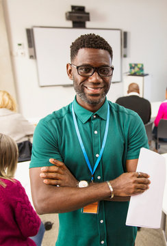 Portrait Confident Smiling Community College Instructor In Classroom