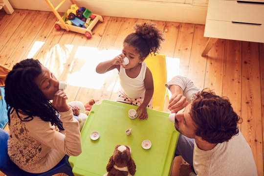 Young family enjoying imaginary tea party