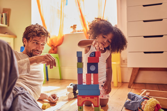 Father and daughter playing with wood blocks