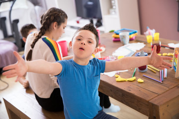 Portrait playful boy with Down Syndrome playing at dining table