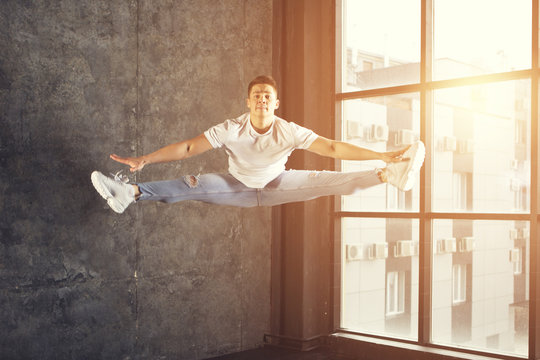 young attractive male dancer doing the splits in jump - Powered by Adobe