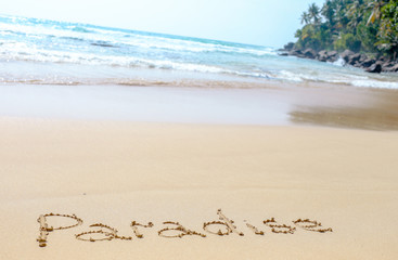 Sand beach of the Indian ocean at Mirissa, Sri Lanka. Hand written words on the beach. Memories of the holiday travel to Ceylon.