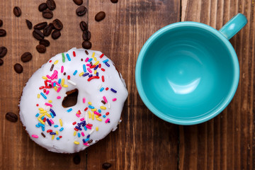 Coffee beans with doughnut and coffee cup on wooden rustic table top