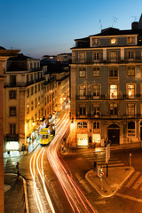 Fototapeta na wymiar Lisbon tram at dawn in beautiful street with historic houses and blue night sky.