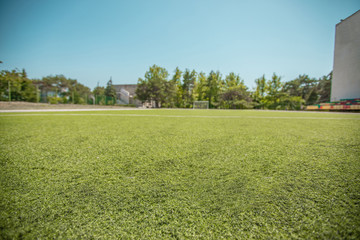 Fototapeta premium Lawn on a football field at a low angle. Soccer ball close up on green grass at extreme point