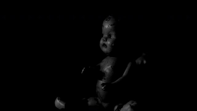 TWO ANTIQUE, CREEPY-LOOKING DOLLS ROTATING IN A SIMULATED LIGHTNING EFFECT.  4K, 10 BIT, 4:2:2 BLACK AND WHITE.